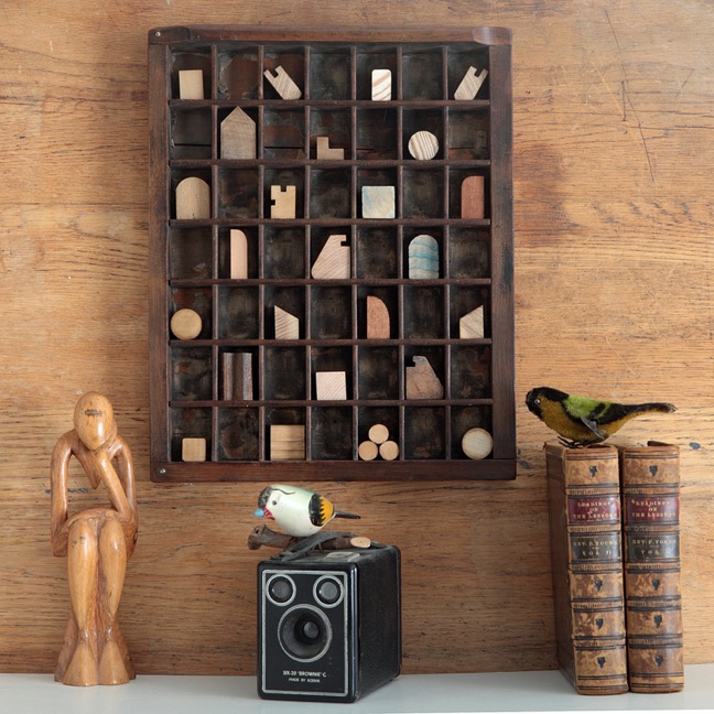 Assemblage artwork of old wooden blocks in an vintage letterpress printers type case drawer tray 