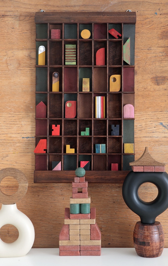 Assemblage artwork of old wooden blocks in an vintage letterpress printers type case drawer tray 