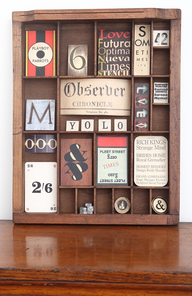 Quirky typographic wall art display in a fittingly old printers type case 