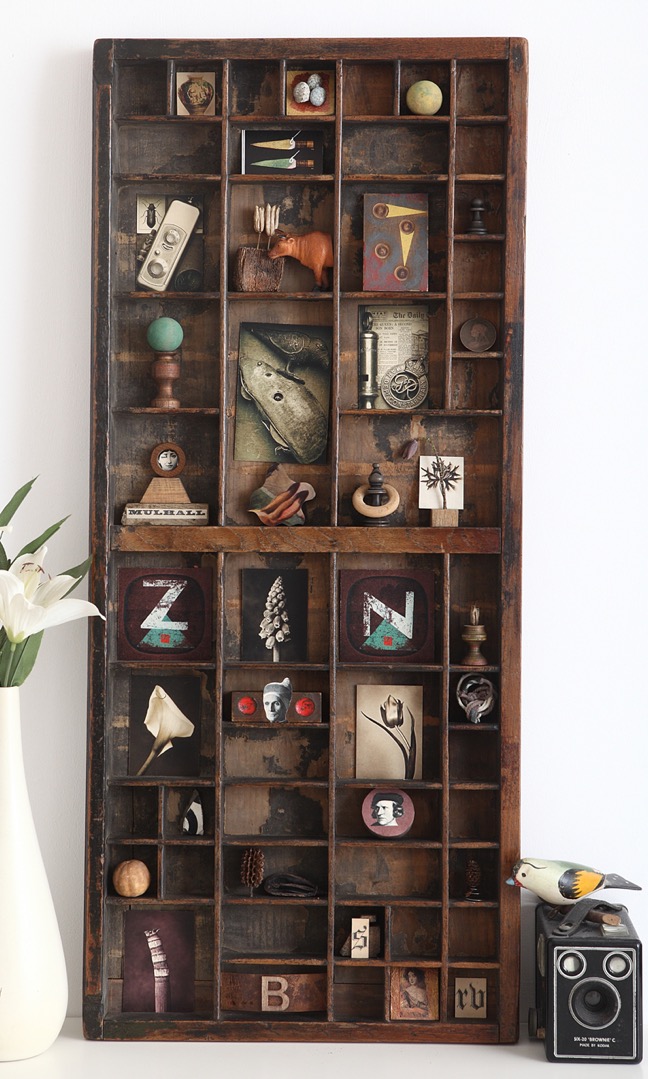 Antique printers cabinet used as a display for quirky items and made into a piece of assemablage art