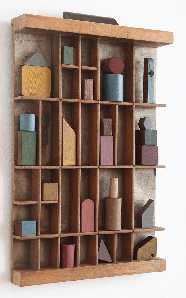 Colourful old wooden buiding blocks and shapes in vintage printers tray 
