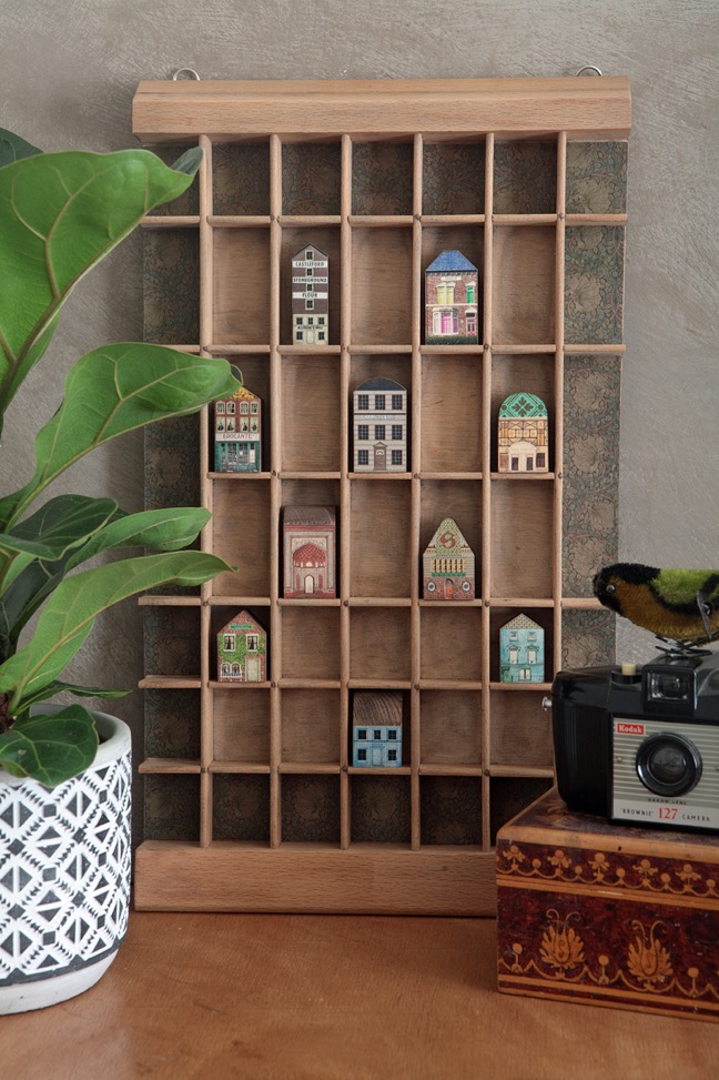 Great quirky cabinet of little handmade wooden houses in a vintage letterpress printers type case