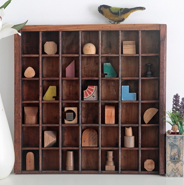 A very woody assemblage art with old wooden block in a re purposed antique letterpress printers tray type case drawer