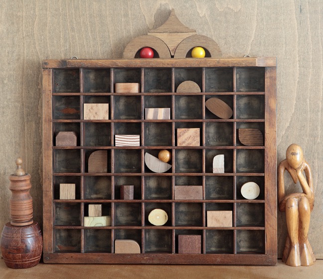 A very woody assemblage art with old wooden block in a re purposed antique letterpress printers tray type case drawer