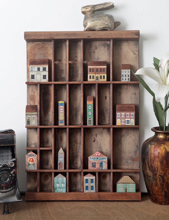 Sixteen little wooden handmade builings in an old Antique letterpress printers type case drawer tray