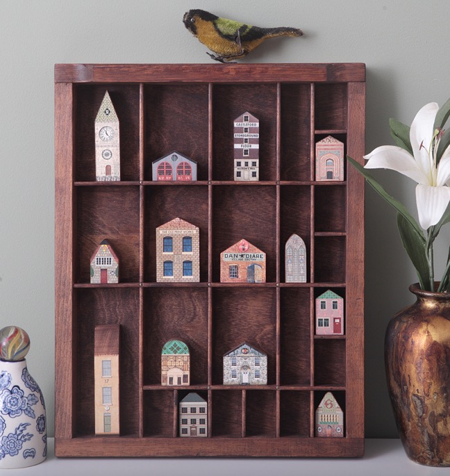 Sixteen little wooden handmade builings in an old Antique letterpress printers type case drawer tray